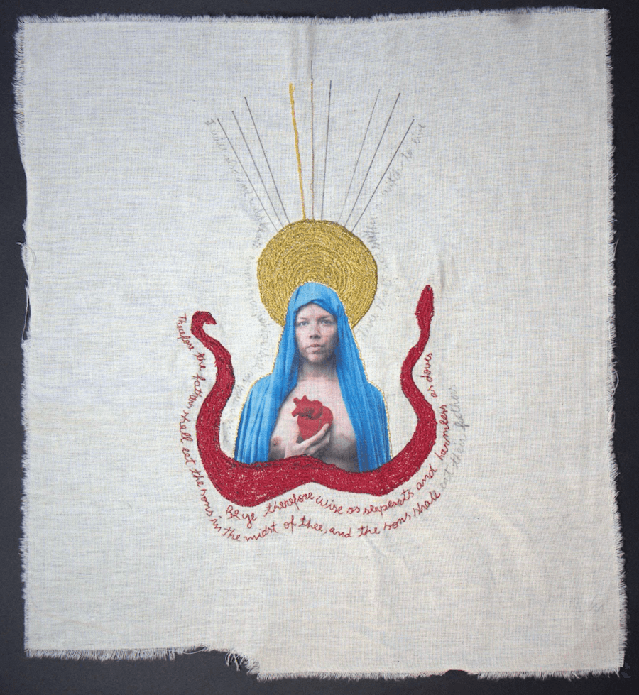 Imagen de un textil bordado de aplique de la Virgen María con algo de texto debajo